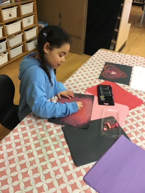 child working on a craft at a table