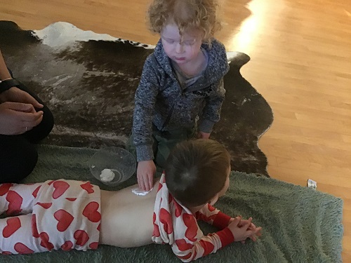 child massaging another child's back during spa day
