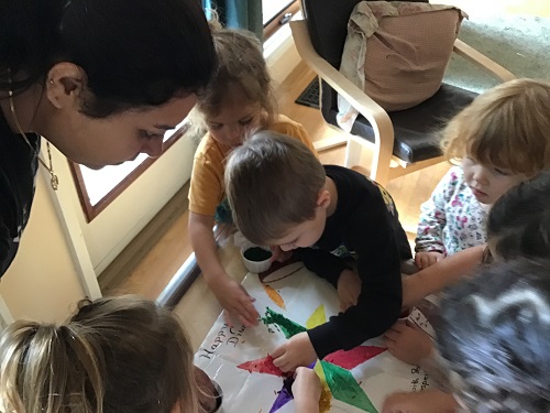 Children cooperativley creating a Rangoli