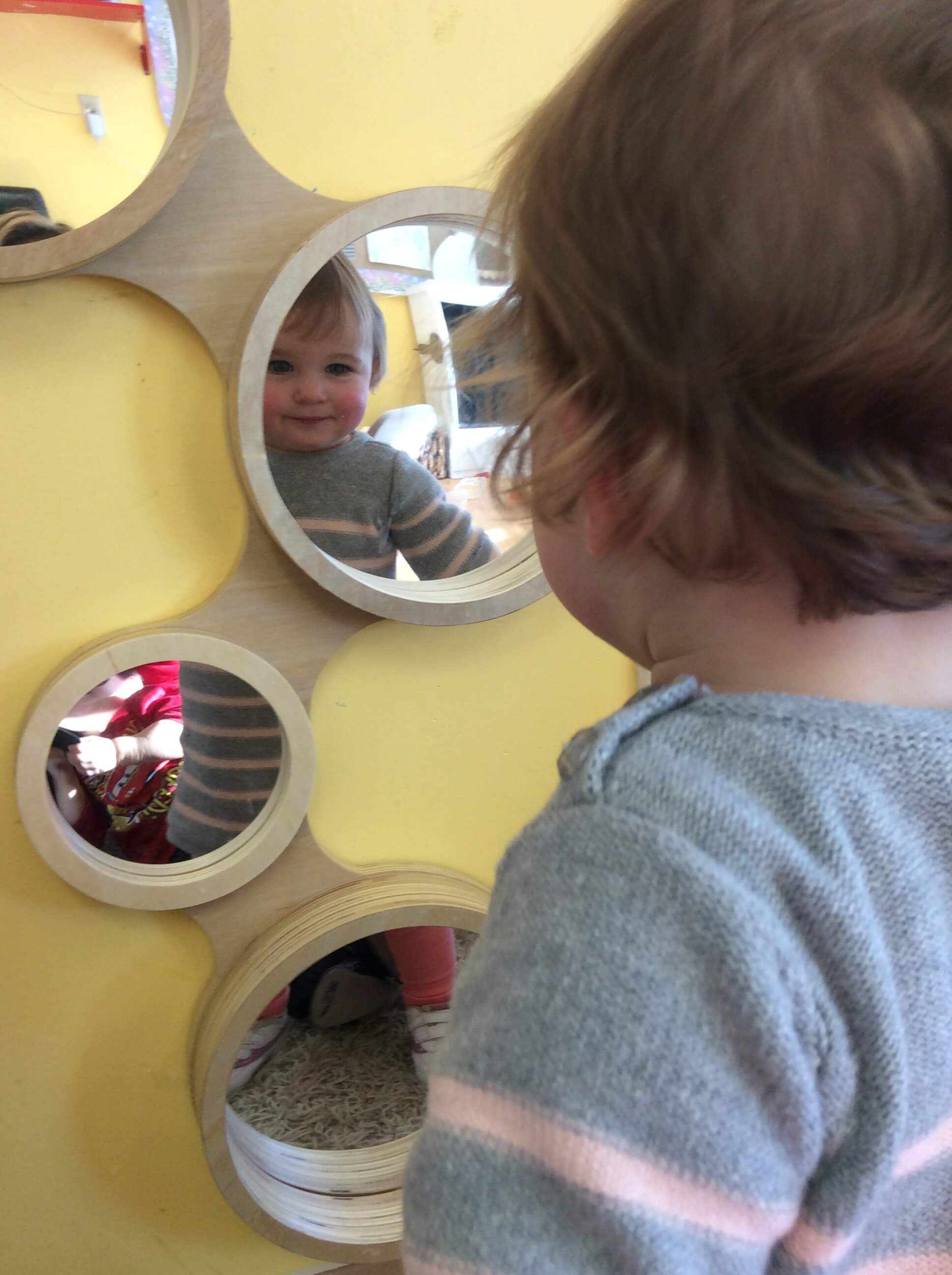 infant looking at her reflection