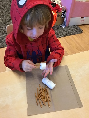 boy building with marshmallows and sticks