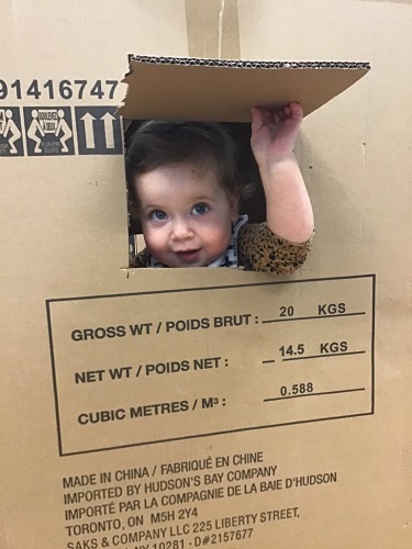 girl peeking out of a box with a hole