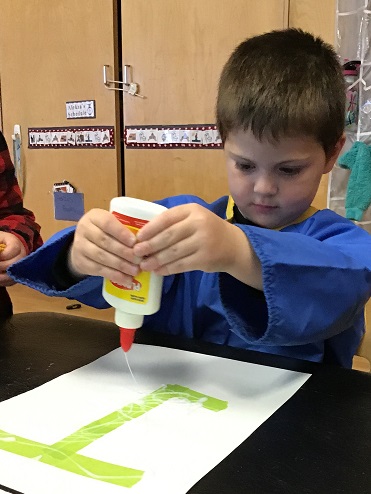 Boy using glue pouring it on paper 