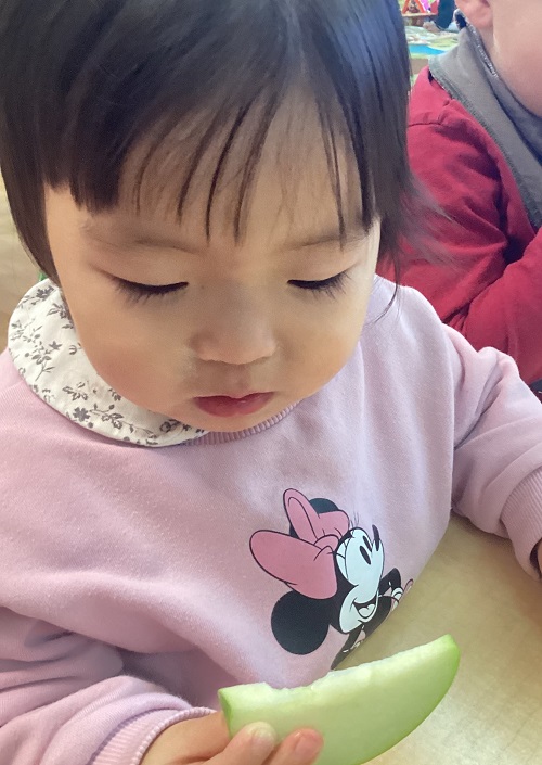child tasting some fresh fruit