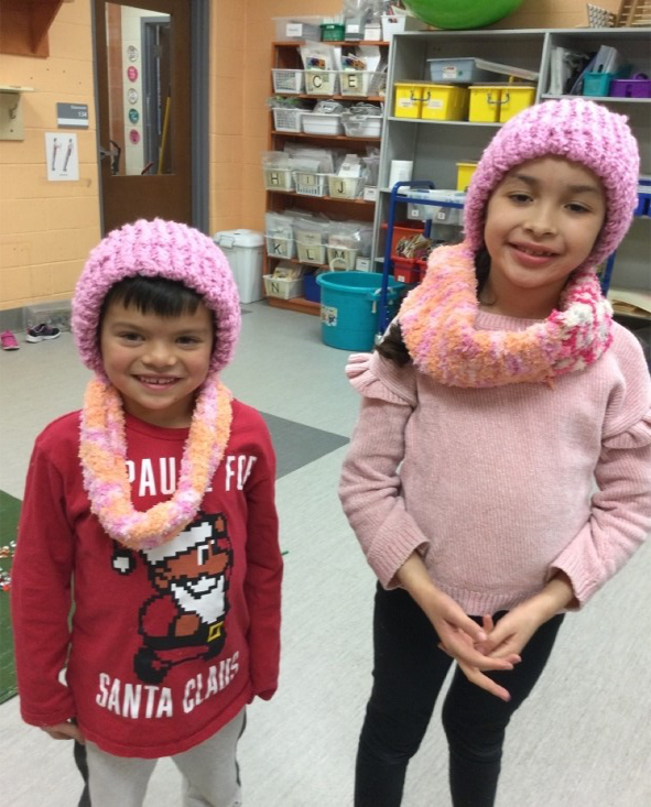 children wearing hats they made for donating
