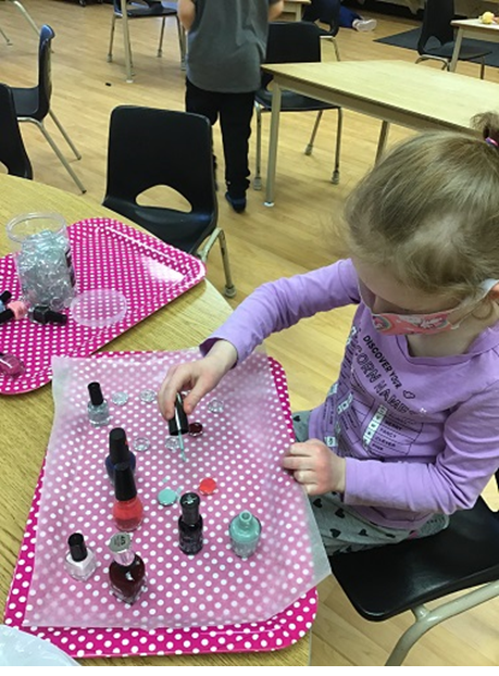 girl painting gems with nail polish