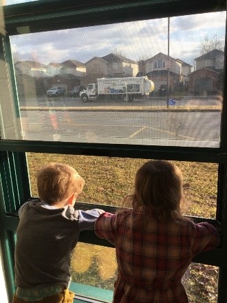 children looking out the window at a recycle truck
