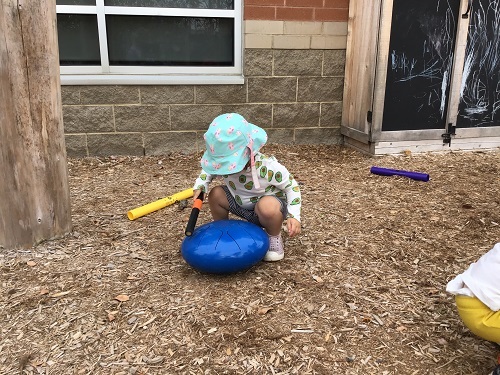 Toddler child exploring the drum outside