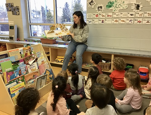 Educator reading "The Colour Monster" to a group of children.