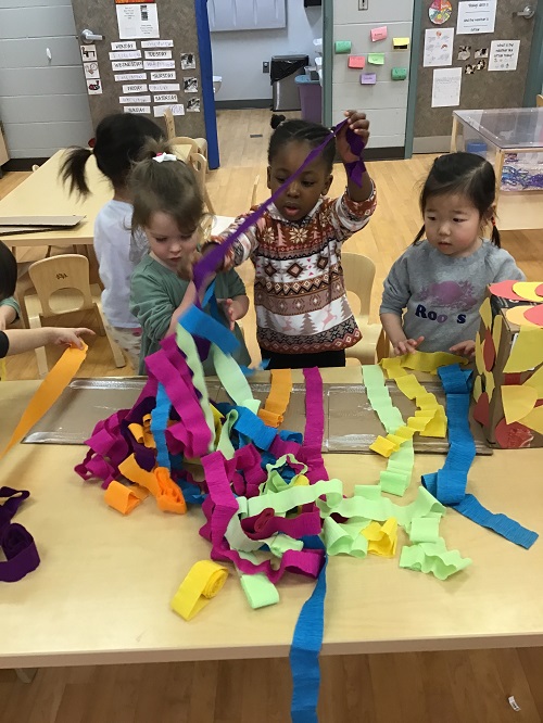 Children working together to create a cardboard dragon.