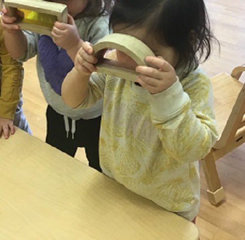 Children looking through transparent blocks. 
