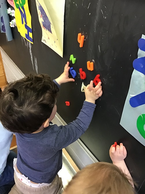 Child observing letters on the blackboard. 