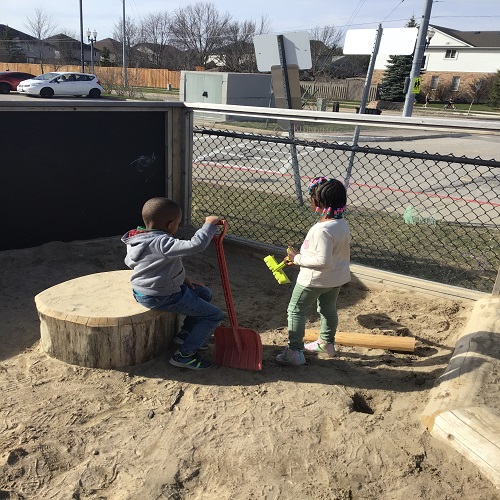 Two children exploring in the sandbox.