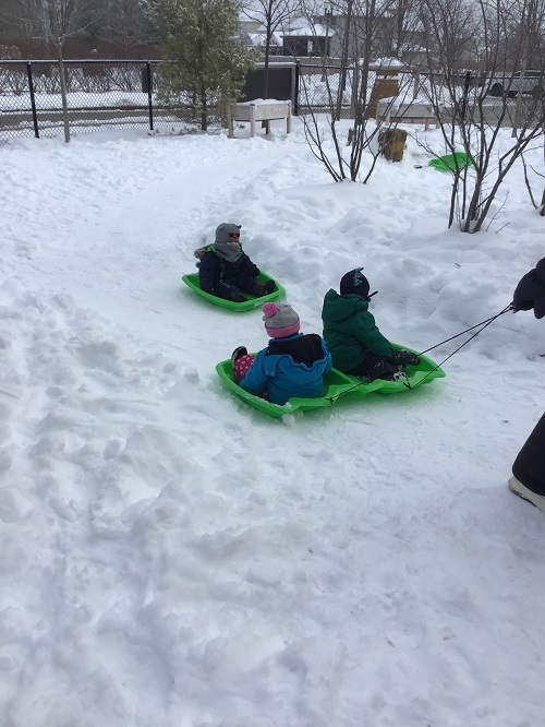 Children being puled on a sled.