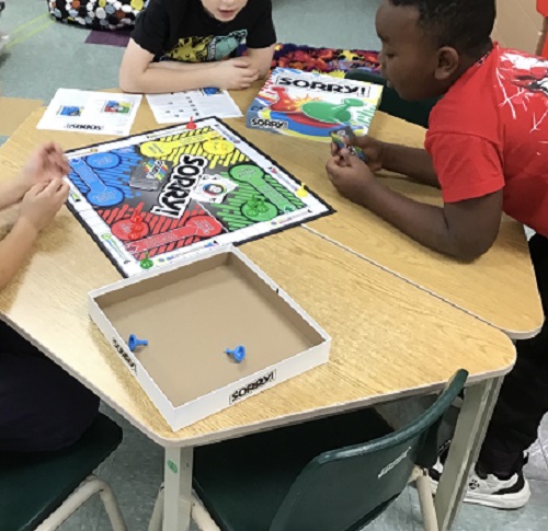 Children playing the board game of "Sorry."