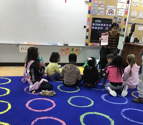 Children and educator sitting and discussing during group time.
