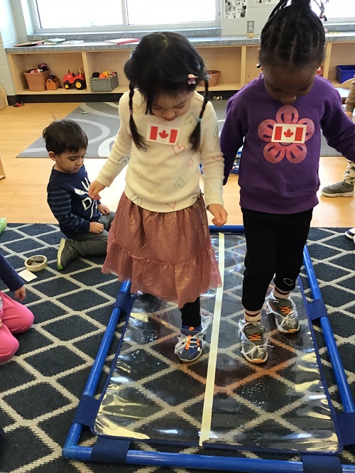 Children pretending to skate on a created indoor rink.