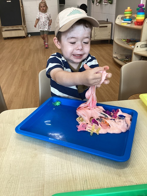 A toddler child playing with slime