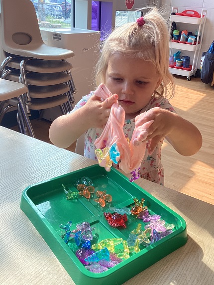 A toddler child playing with slime