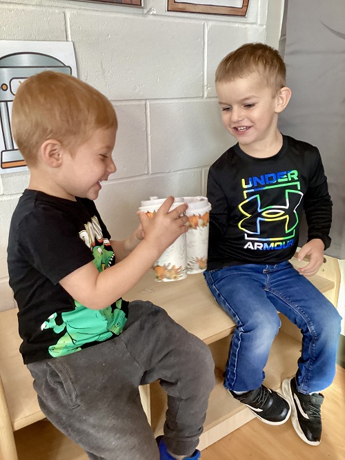 Preschool children cheersing their pretend coffee cups together