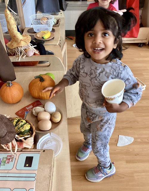A preschool child playing in their farmers market