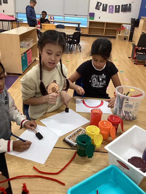 Children sitting at a table doing artwork.