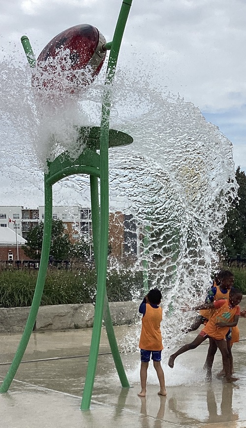 Summer camp children playing at a splash pad