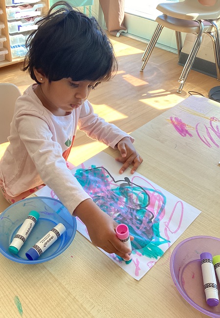 A toddler child colouring their photo