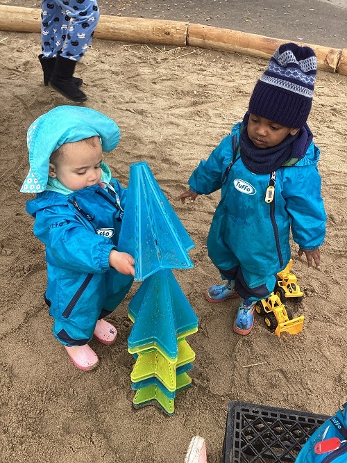 Children collaboratively stacking star pylons into a pile