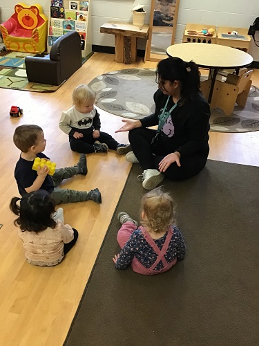 Toddlers engaged with children on the carpet