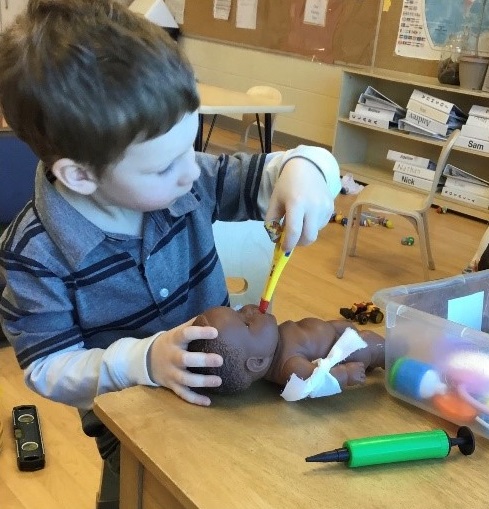 child feeding a doll