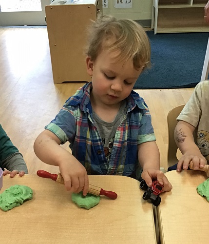 A child playing with green playdough