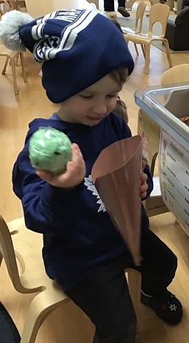 A child hilding the paper ice cream and looking into the cone